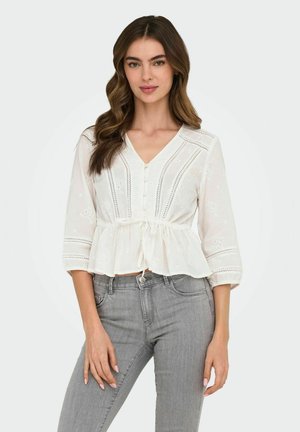 Blouse peplum blanche avec décolleté en V, fermeture à boutons et détails brodés. Dotée de manches trois-quarts et d'une taille à nouer.