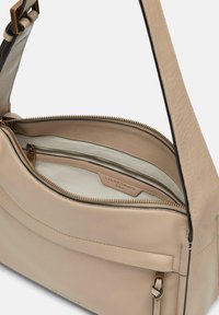 Borsa a tracolla in pelle beige con una texture liscia, dotata di un compartimento con zip e hardware in tono oro. L'interno include un dettagli etichetta.