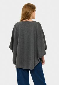 Pelēks pončo džemperis, izgatavots no mīksta adījuma, ar brīvu dizainu, plašām piedurknēm un apaļu kakla izgriezumu. Piemērots slāņošanai.