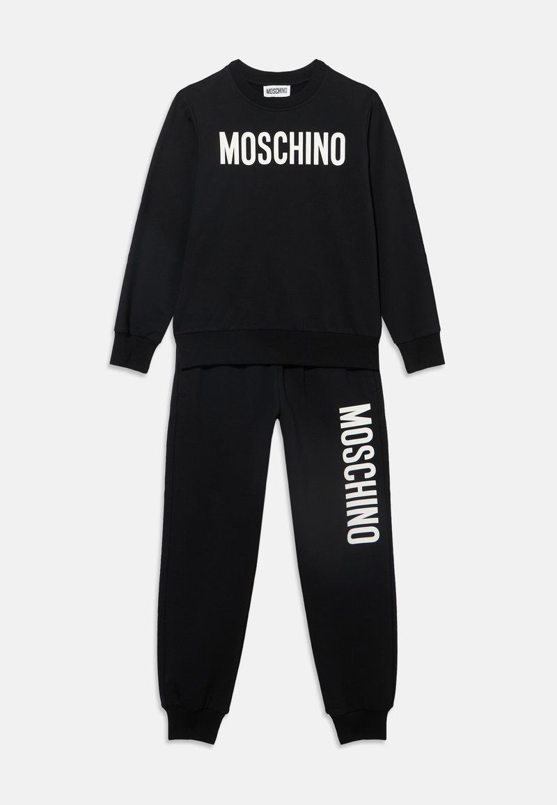 Μαύρη φόρμα με λευκό λογότυπο Moschino τυπωμένο στο στήθος και στο αριστερό πόδι σε λευκό φόντο.