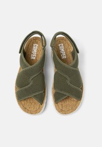 Green mesh sandals with crossed straps, cork footbed, and white rubber sole. Brand name "Camper" visible on the insole.