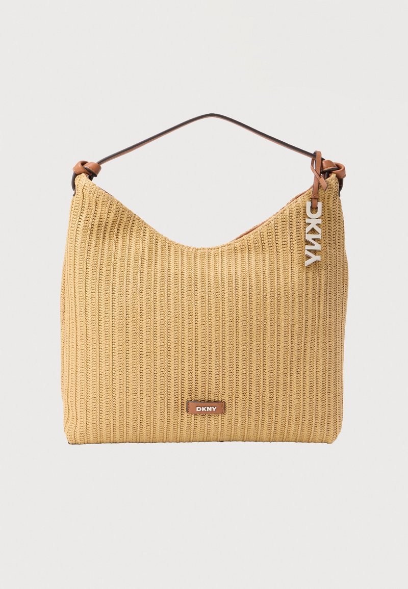 Sac à épaule tissé beige avec anse marron, plaque logo DKNY et breloque argentée suspendue à la bandoulière.
