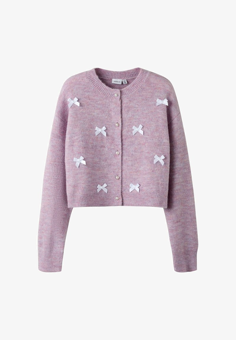 Rozā nospriegotā kardigāna, kas izgatavota no mīksta materiāla, ar baltām lentes loku un pērļu pogām priekšpusē. Cimdi un apakšdaļa ar ribām.