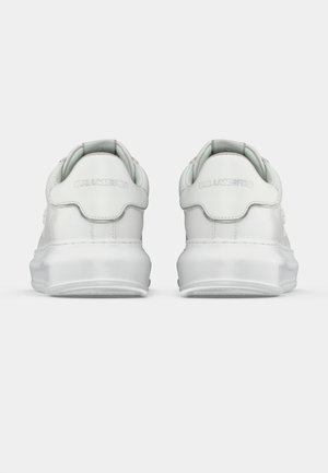 Paar weiße Sneakers, von hinten gezeigt, mit "Karl Lagerfeld" auf den Fersenlaschen geprägt und dicken weißen Sohlen.