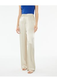 Pantaloni a gamba larga in satin beige chiaro con una superficie liscia e vita alta, dotati di chiusura frontale e tasche laterali.