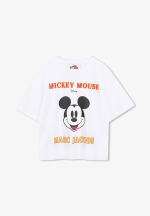 Biała krótka koszulka z dużym czarno-białym graficznym wizerunkiem Myszki Miki. Napis w kolorze czerwonym i żółtym brzmi "MICKEY MOUSE" oraz "MARC JACOBS."