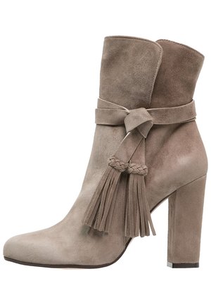 Bottine en daim taupe avec bout pointu, talon carré, et brides décoratives à glands tressés enroulées autour de la tige.