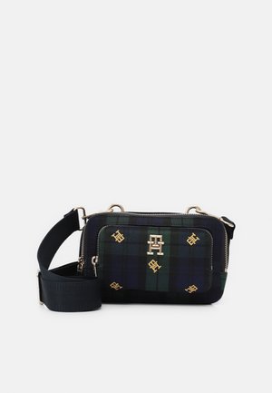 Petit sac bandoulière rectangulaire avec motif à carreaux vert foncé et bleu marine, détails du logo de la marque en or, poche zippée devant, et large sangle noire réglable.