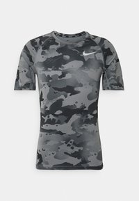 Kortärmad grå kamouflagemönstrad sporttröja, tillverkad av ett mjukt tyg, med rundad halsringning och en liten logga på övre vänstra sidan.