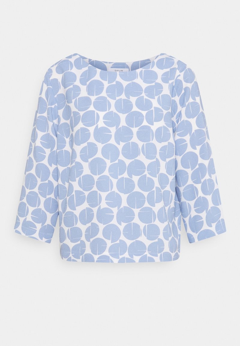 Haut blanc à manches longues avec un large décolleté, présentant un motif de grandes formes circulaires bleu clair avec des lignes abstraites à l'intérieur.