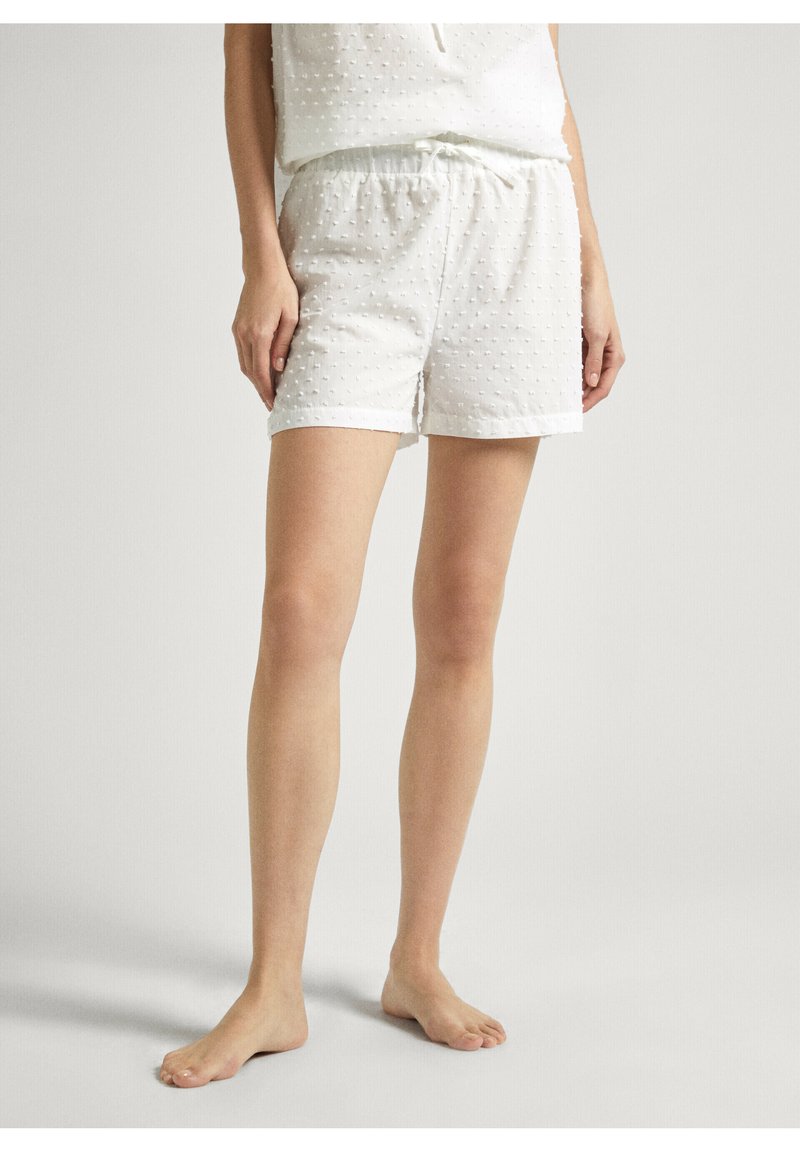 Weiße, strukturierte Shorts aus einem weichen Stoff, mit elastischem Bund und Kordelzug-Details. Besitzt ein kleines Punktemuster auf der Oberfläche.
