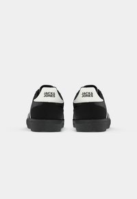Pair of black and white Jack & Jones sneakers shown from the back on a white background.