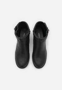 Stivaletti neri in pelle con finitura liscia, punta tonda e zip laterale. Include un dettagliato cinturino decorativo con fibbia sulla caviglia.