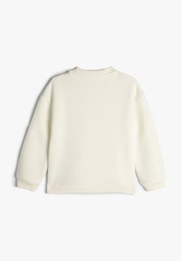 Sudadera de crema claro con cuello alto, hombros caídos y puños de canalé. Confeccionada en una tela suave, presenta una textura simple y lisa.