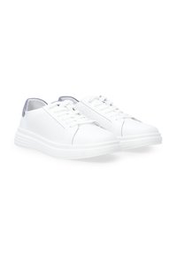 Weiße Sneakers mit einem strukturierten Mesh-Panel, runder Zehenpartie, Schnürdesign und einem hellgrauen Akzent an der Ferse, ausgestattet mit einer dicken weißen Sohle.