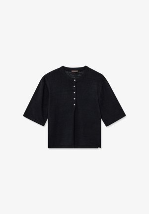 Top negro de punto con mangas cortas, escote redondo y cinco botones blancos en el centro delantero.