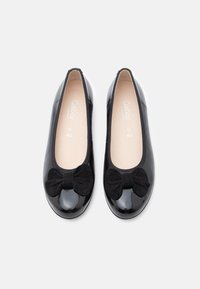 Μαύρα μπαλαρίνες από δέρμα με βινύλ, διακοσμημένες με υφασμάτινο μαύρο φιόγκο σουεντ μπροστά. Στρογγυλερή μύτη και μαξιλαρωμένο εσωτερικό για άνεση.
