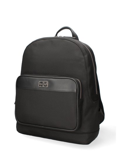 Sac à dos en tissu noir avec une surface texturée, doté d'une poche en cuir à l'avant, de garnitures en métal argenté et d'une poignée de transport supérieure.