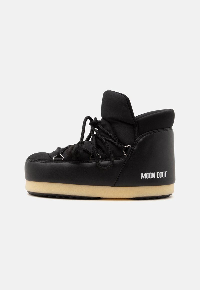 Botte noire Moon avec cheville haute rembourrée, semelle beige épaisse et lacets noirs sur fond gris uni.