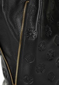 Sac en cuir noir doté d'une surface texturée avec un embossage et une fermeture éclair dorée. Les motifs notables incluent des formes géométriques et des symboles.