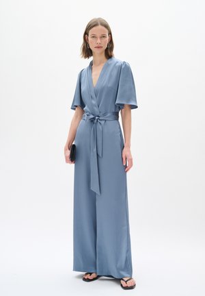 Hellblauer Jumpsuit mit Wickeldesign, kurzen Ärmeln, einem Bindegürtel in der Taille und weitem Bein. Glattes Textilgewebe.