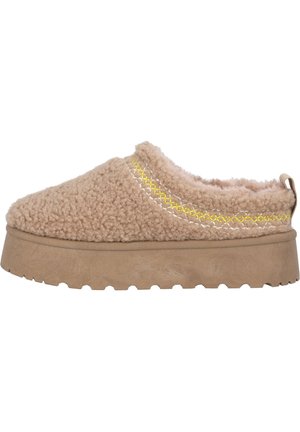 Beige slip-on shoe with a fluffy texture, featuring a thick sole and yellow stitching detail along the top edge.
