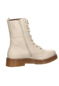 Botte de combat en cuir couleur crème avec fermeture éclair latérale, lacets à l'avant et semelle rainurée marron.