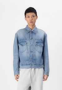 Lichtblauwe denim jack met een klassieke snit, voorzien van een knoopsluiting aan de voorkant, twee borstzakken en een kraag. Zachte textuur.