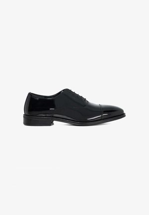 Black patent leather dress shoe with a rounded toe, closed lacing, and a low stacked heel. Features subtle stitching and a glossy finish.
