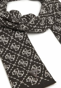 Sciarpa lavorata a maglia color marrone scuro con un motivo bianco ripetuto; presenta un'etichetta triangolare con il logo Guess nella parte inferiore. Texture morbida.