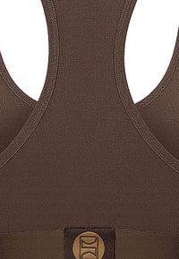 Brun sports-BH med rund hals, brede stropper og teksturert stoff. Gullfarget logo på frontbåndet.