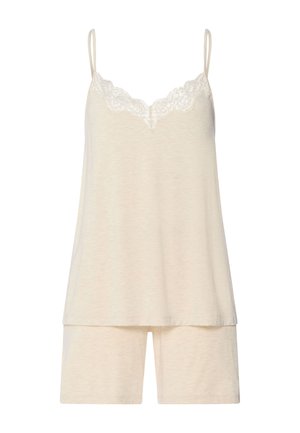 Top sin mangas color crema con encaje en el escote, combinado con pantalones cortos a juego hasta la rodilla.