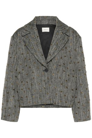 Zrezaný blejzer s houndstooth vzorom; čiernobiely s zlatými flakes. Obsahuje výstrih s klopami a jedno tlačidlové zapínanie. Textúrovaná tkanina.