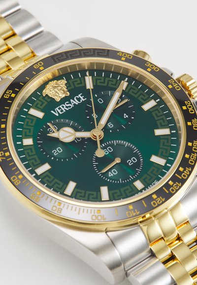 Versace watch with a green dial, gold accents, and silver and gold band. Features three sub-dials, bold hour markers, and detailed bezel.