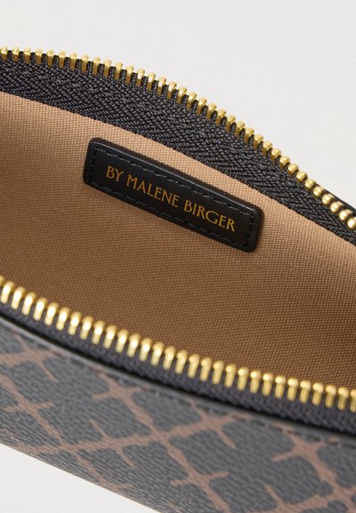 Μαύρο υφασμάτινο πουγκί με χρυστό φερμουάρ. Το εσωτερικό διαθέτει μπεζ επένδυση και μαύρη ετικέτα με την επιγραφή "BY MALENE BIRGER." Περιέχει σχέδιο με λεοπάρ μοτίβο.