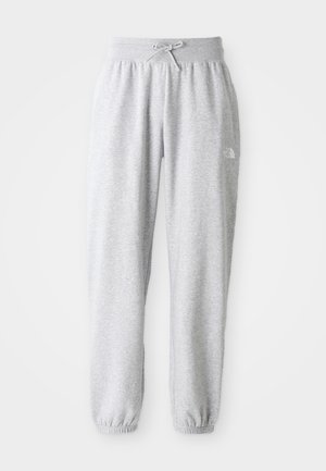 Lys grå fleece joggerbukser med elastisk livrem og manchetter, snørebind, og lille hvidt logo på højre lår.