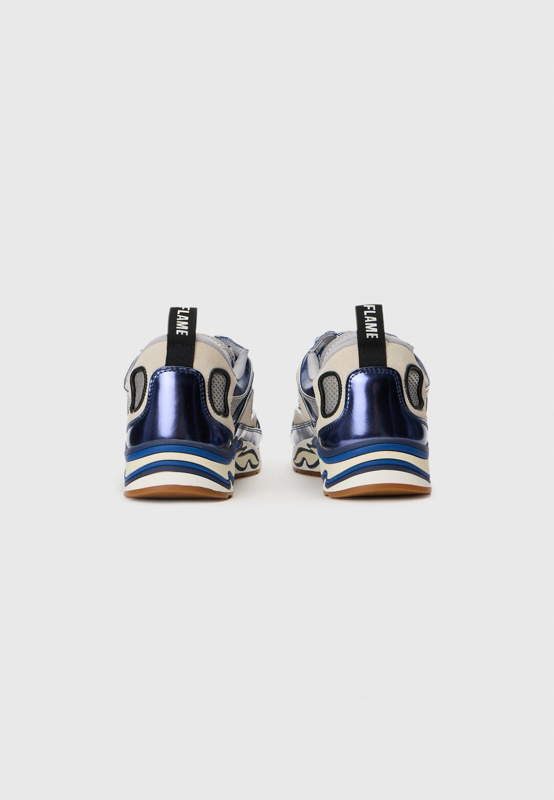 Blaue metallische Sneaker mit beigen Akzenten, strukturierten Seitenpaneelen und blauer Streifenverzierung an der Sohle. Der schwarze Ziehstrippe hat den Aufdruck "FLAME".