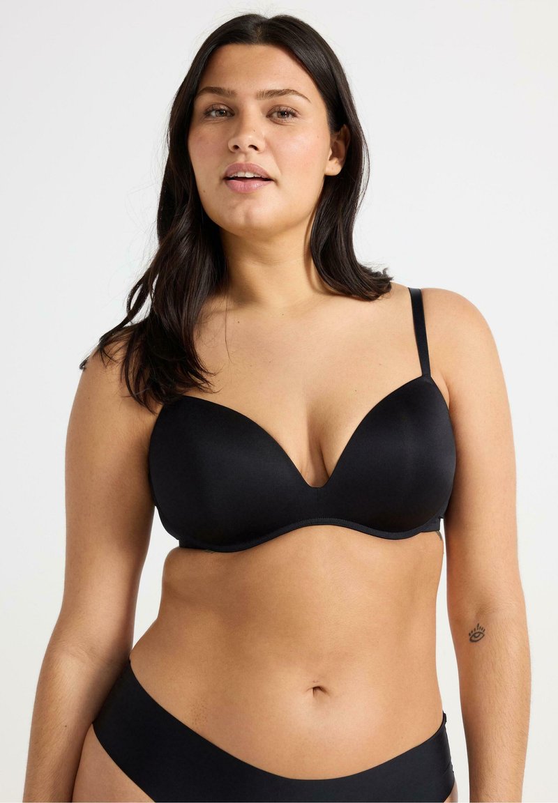 Reggiseno imbottito nero con scollatura profonda, texture liscia, spalline regolabili e design senza cuciture. Nessun hardware o decorazione visibile.
