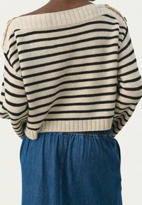 Raidallinen neulepaita leveällä pääntiellä, mustavalkoiset raidat, resorit hihansuissa ja helmassa, olkapäällä nappikoristein.