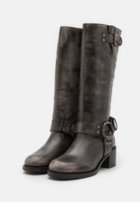 Czarne skórzane kozaki za kolano z lekko teksturowanym wykończeniem, zdobione paskami z klamrami, na stabilnym obcasie typu klocek.