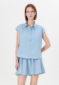 Light blue denim shirt dress with short sleeves, button front, and flared skirt. Fabric has a smooth texture and casual design.