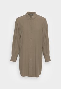 Chemise à manches longues, à boutons, de couleur olive, fabriquée en tissu léger. Dotée d'un col classique et de manches froncées. Texture lisse.