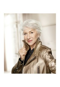 Veste en cuir doré métallique avec col pointu, détails de fermeture éclair et accents à pression, portée par une personne avec des cheveux argentés courts.