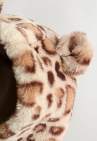 Tivă moale din blană sintetică cu un model de leopard în nuanțe de bej și brown și detalii de pom-pom pufoase, rotunde, pe o glugă, pe un fundal simplu.