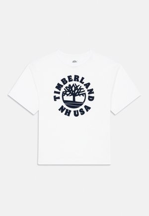 T-shirt en coton blanc avec un col rond, arborant un logo circulaire bleu marine avec "TIMBERLAND NH USA" et un design d'arbre au centre.