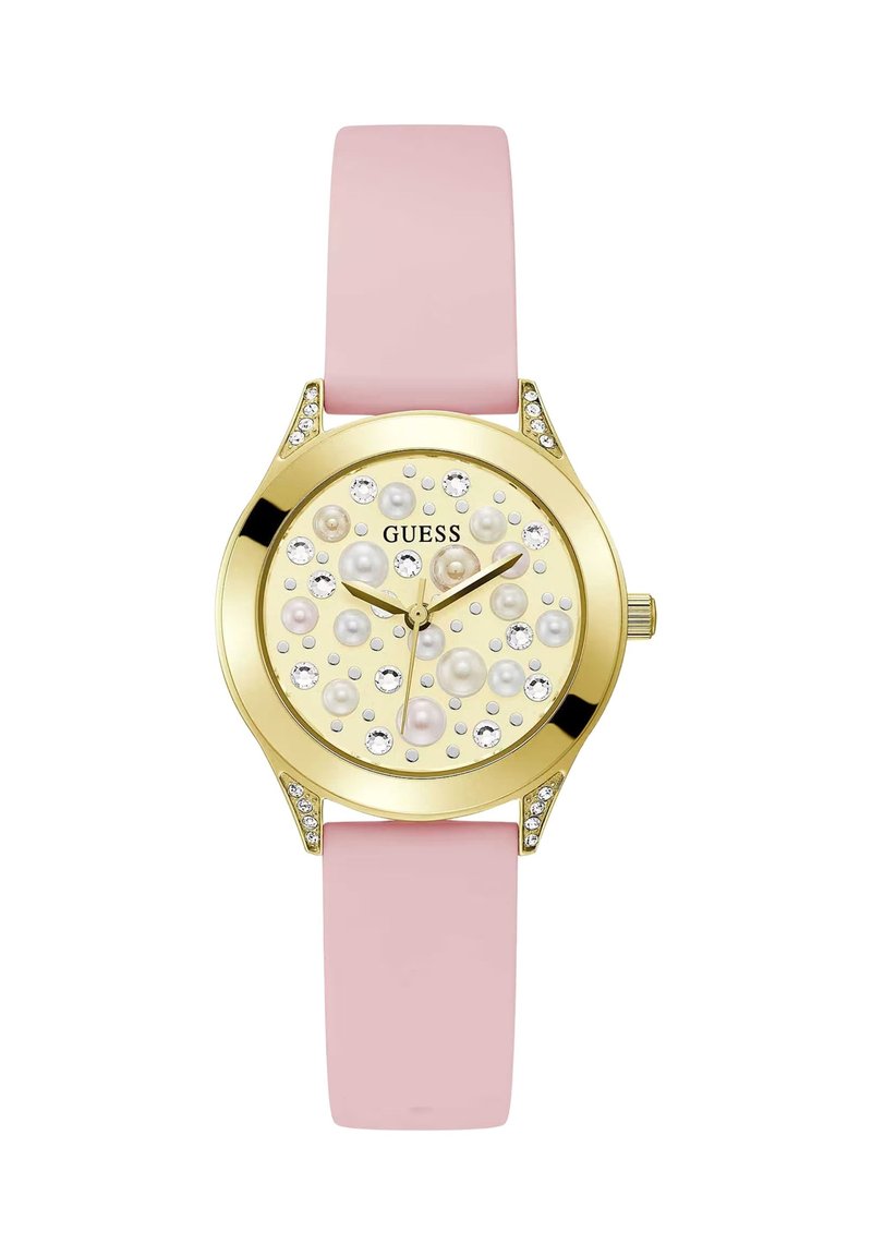 Kuldtooniline Guess käekell, millel on roosa silikoonriba, kaunistatud dial ja pärlid ning kristallid, ning kolm kuldset käe, mis näitavad aega.