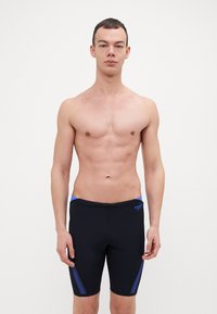 Shorts de bain noirs avec des accents bleus, un design ajusté et des détails texturés sur les côtés, fabriqués en matériau extensible et évacuant l'humidité.