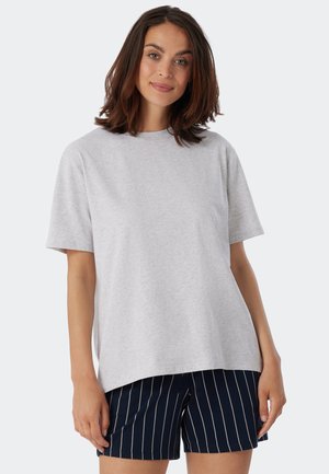 Ljusgrå kortärmad t-shirt med avslappnad passform, tillverkad av mjukt bomullsmaterial. Matchad med marinfärgade randiga shorts för kontrast.