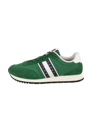 Green athletic shoe featuring a mix of suede and fabric materials, white stripes with branding, and a rubber sole for traction.