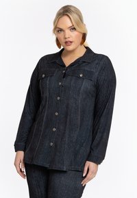Donkerdenim overhemd met lange mouwen, knoopsluiting, twee borstzakken en subtiele verticale strepen. Heeft een klassieke kraag en een gestructureerde stof.